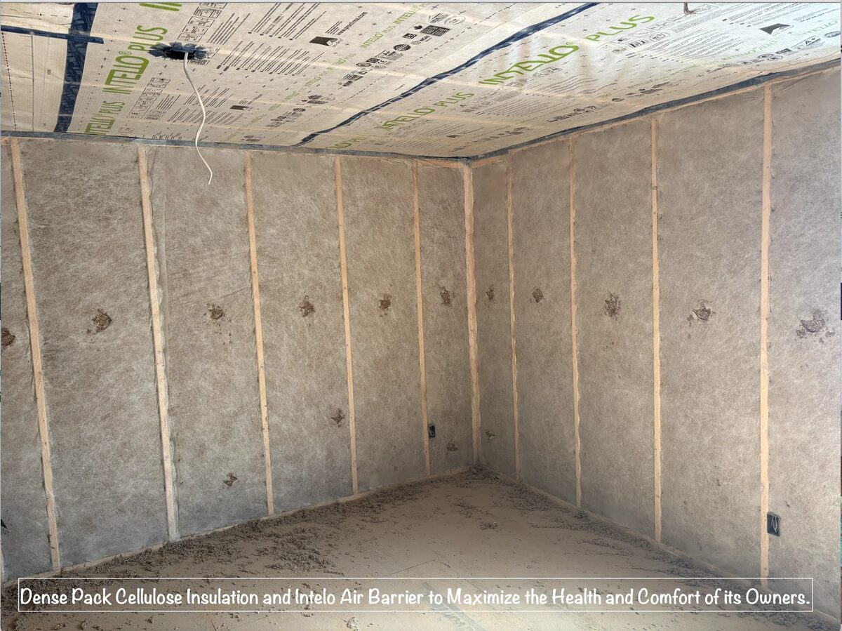 A wall cavity packed with dense pack cellulose insulation behind a taped membrane